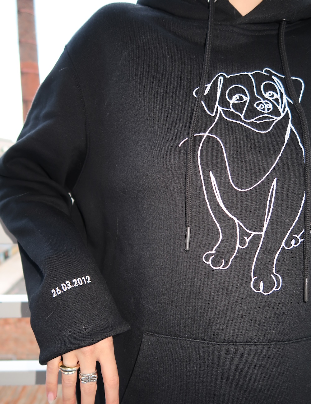 Black hoodie personalized with a dog embroidery on the sleeve